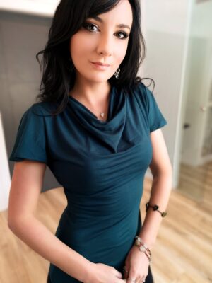 Green cowl neck top with draping sleeve.