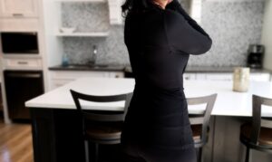 Black long-sleeve fitted cowl neck top.