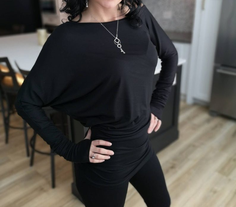 Black off-the-shoulder unsymmetrical draping tunic top.