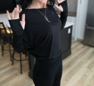 Black off-the-shoulder unsymmetrical draping tunic top.