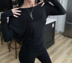 Black off-the-shoulder unsymmetrical draping tunic top.