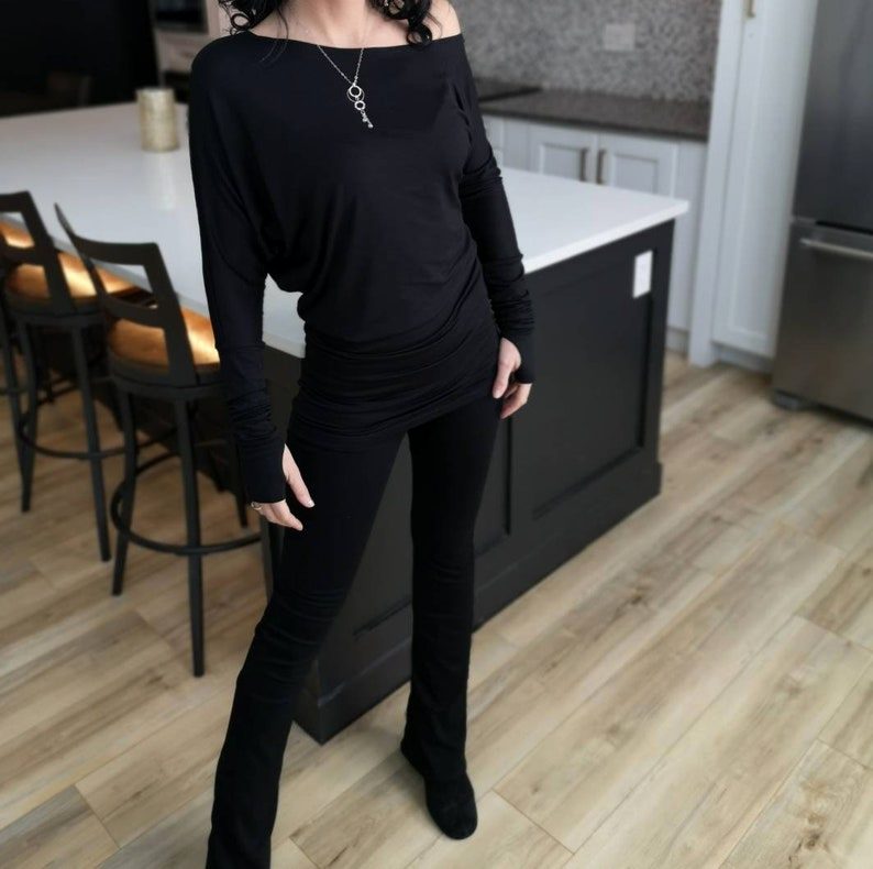 Black off-the-shoulder unsymmetrical draping tunic top.