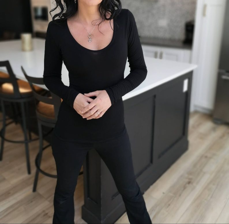 Soft fitted low-cut long sleeve black top.