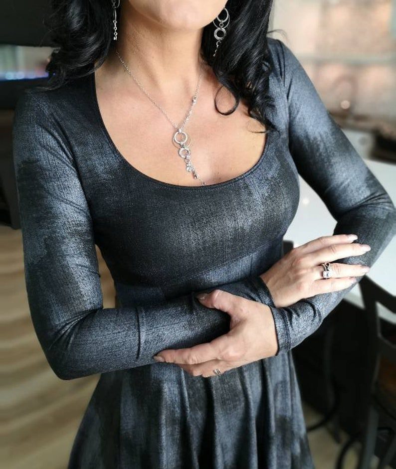 Metallic black long-sleeve low-cut neckline tissue hem dress.