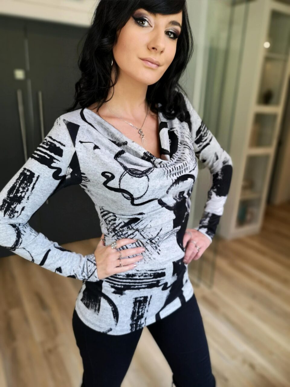 Gray and black cowl neck long-sleeve fitted top.