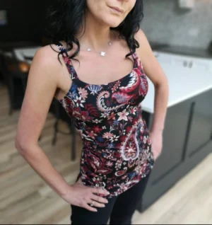 Fitted tank top, in red paisley with touches of white, mauve and blue on black.