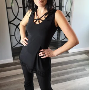 Black sleeveless top with lace trimming around the bottom and string detail.