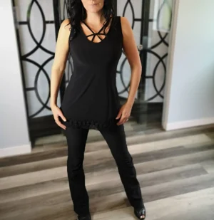 Black sleeveless top with lace trimming around the bottom and string detail.