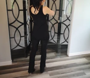 Black sleeveless top with lace trimming around the bottom and string detail.