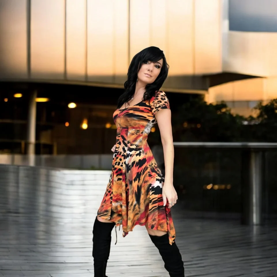 Cap sleeve orange, black and yellow animal print tissue hem round neck mini dress.