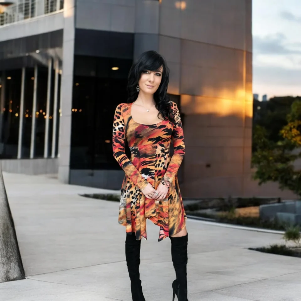 Long-sleeve orange, black and yellow animal print tissue hem round neck mini dress.