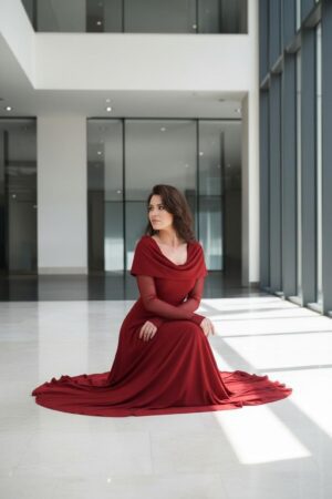 Scarlet red hooded cowl neck maxi dress with mesh sleeves and finger cutouts.